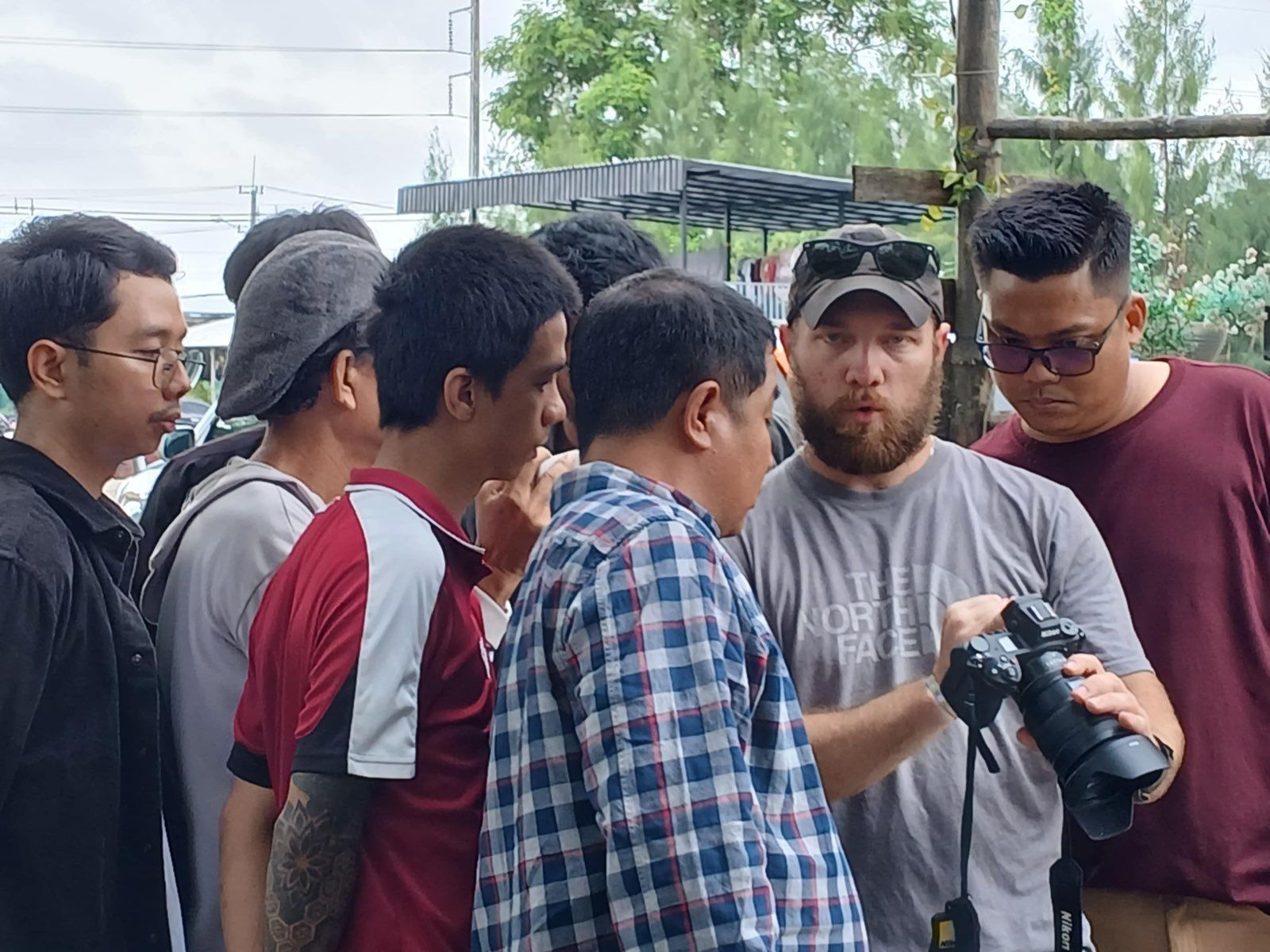 A group gathered closely around a long telephoto lens during a demonstration