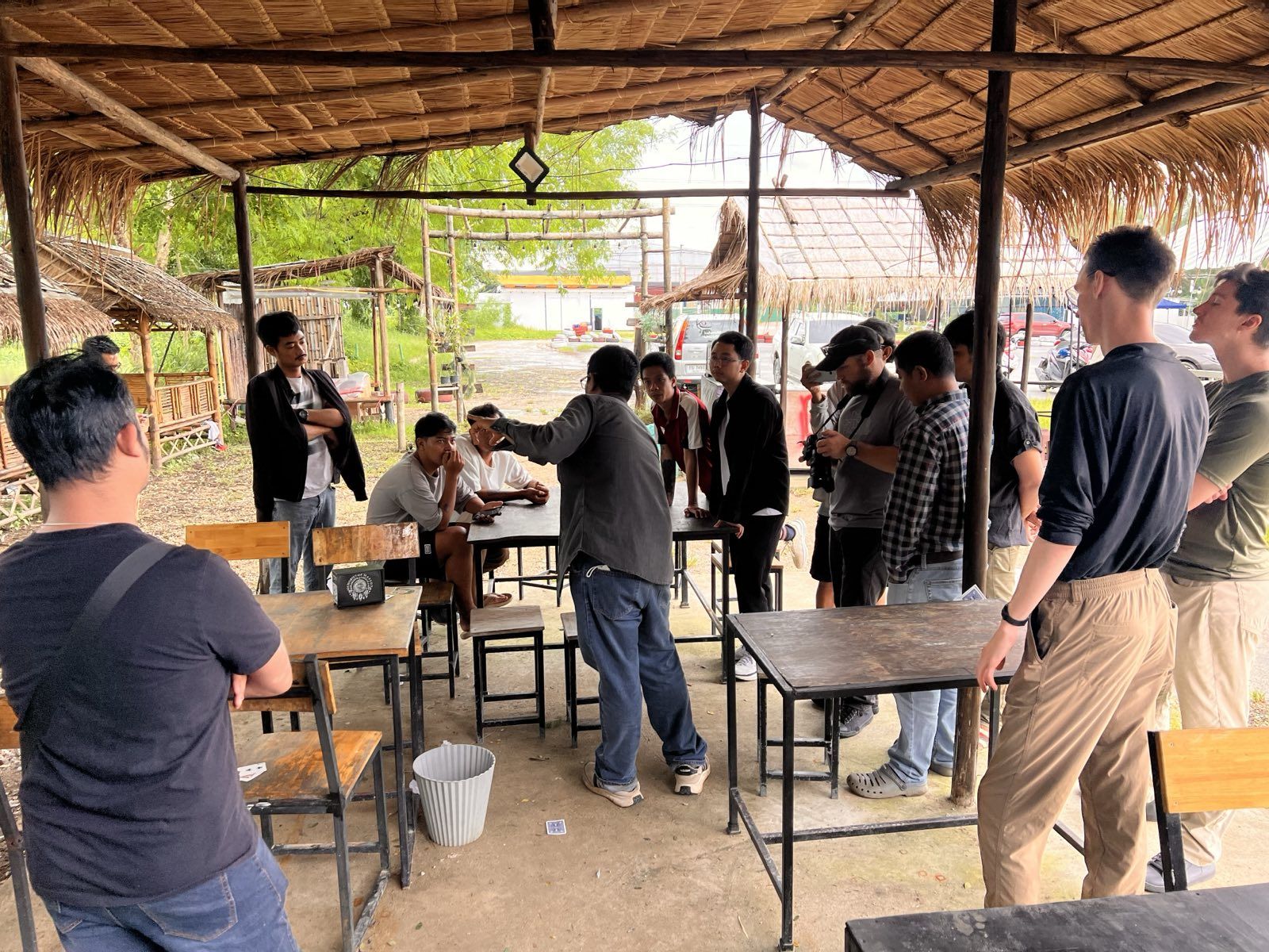 A small group leaning in around a table while an instructor demonstrates