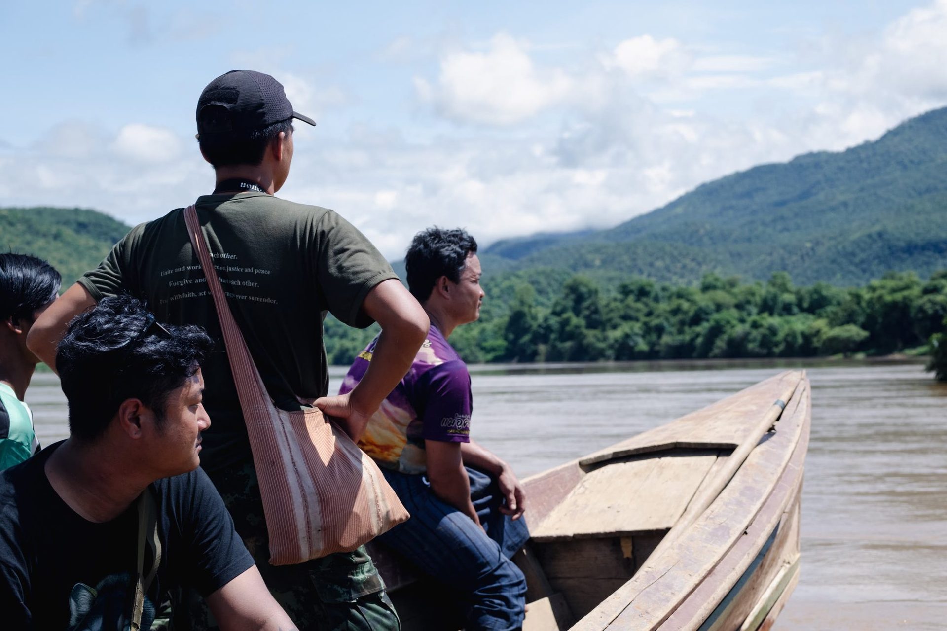 A crew crossing a river by longboat on the way to a shoot